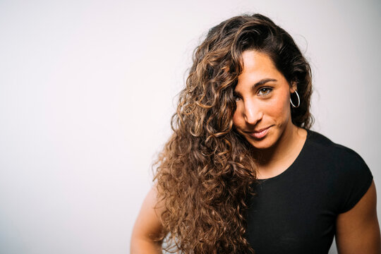 Young adult woman smiling with stunning curly hair