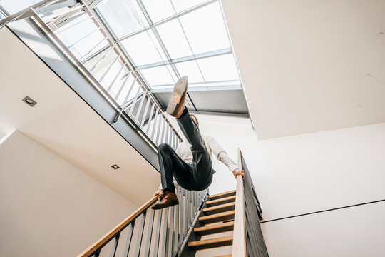 Businessman jumping down stairs
