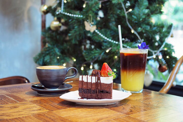 A piece of homemade chocolate mousse cake  decorated with mint leaf and fresh strawberry topped with white cholocate and chocolate sauce on the ceramic plate. © Theerawan