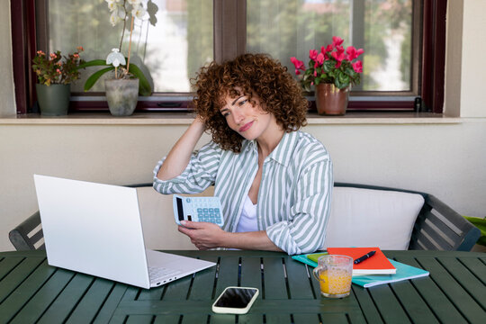 Freelancer calculating budget outdoors at home with laptop