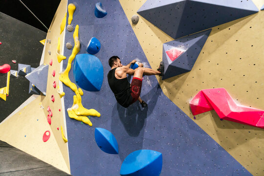 Athlete climbing on bouldering gym wall