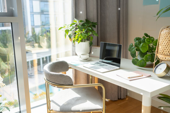 Laptop kept on desk in front of chair at home office