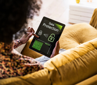 Woman checking tablet data protection while relaxing at home