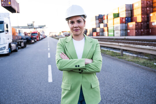 Logistics manager in helmet standing at shipping port