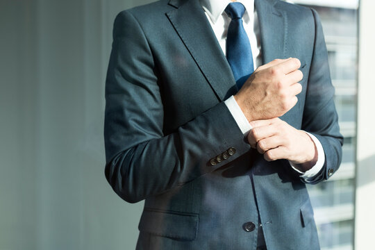 Businessman adjusting cuffs