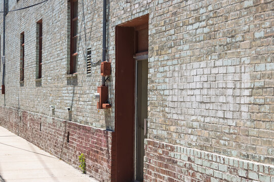 Old urban brick wall texture with alleyway and architectural detail