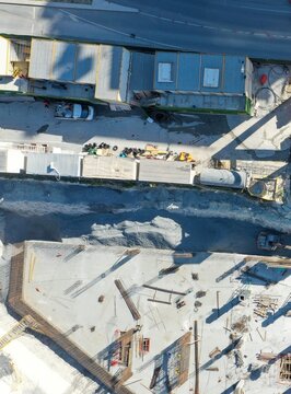 Aerial view of a construction site featuring heavy machinery, piles of gravel, steel reinforcement bars, and temporary site offices in Istanbul, Istanbul, Turkiye.