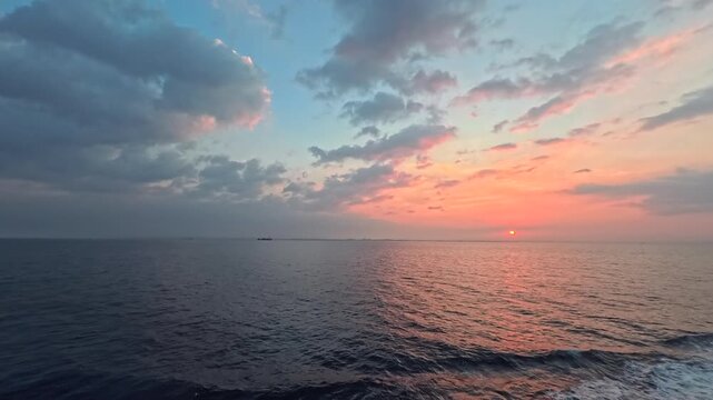 Real-time maritime sunrise footage with dramatic clouds and colorful twilight gradient sky
