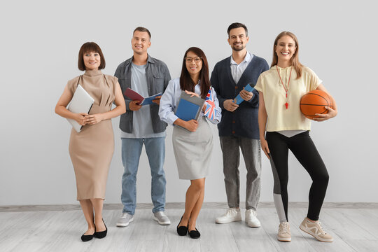 Group of teachers smiling near light wall