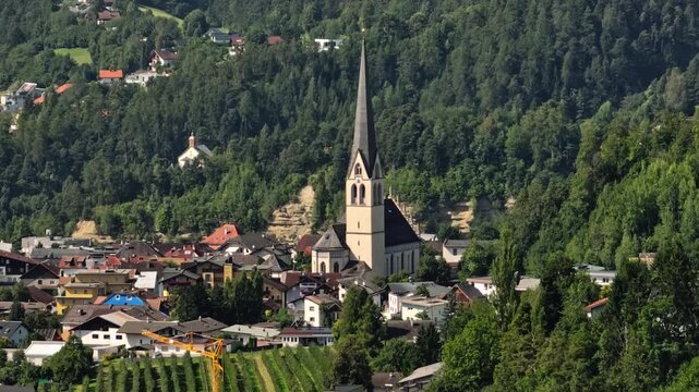 Scenic aerial view of Imst Austria with historic cathedral in the village center surrounded by alpine valleys majestic mountains and European tourism