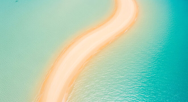 Aerial top view of a winding sandbar surrounded by crystal clear turquoise ocean water