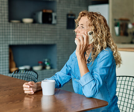 Portrait of a mature senior woman or a  businesswoman working from home having a meeting online, home office, or a student learning, or mature woman having a phone call, holding a mobile phone, smartp