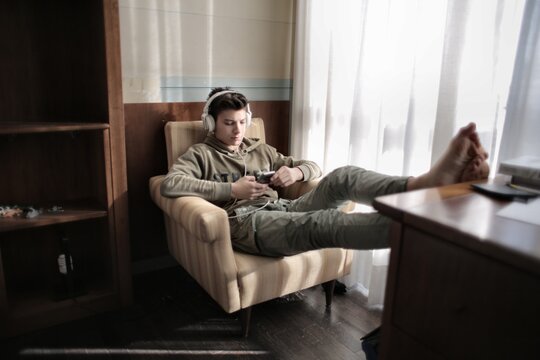 Teenager listening to music with feet on desk