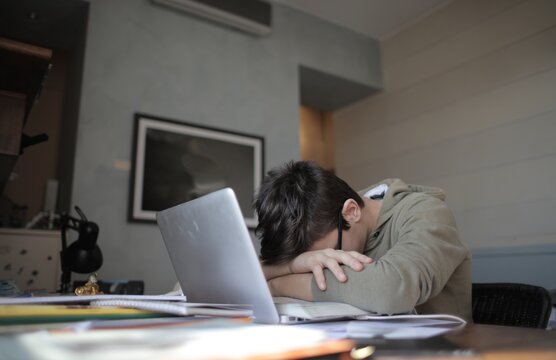 Tired student falls asleep while studying with laptop
