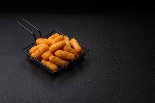 Mozzarella cheese sticks, breaded and fried with salt and tomato sauce, for takeaway. Cheese sticks
