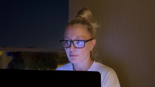 Woman working on computer at home,works remotely at a computer at home.