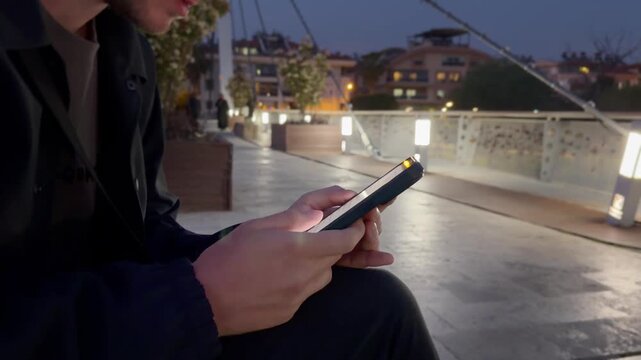 Lifestyle portrait of young man using a smartphone outdoors