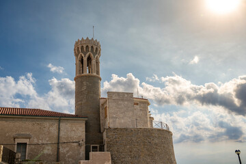 Obraz premium Historic Church of Saint Clement Bell Tower in Piran Slovenia Under Dramatic Summer Clouds on the Adriatic Coast Mediterranean Heritage Architecture