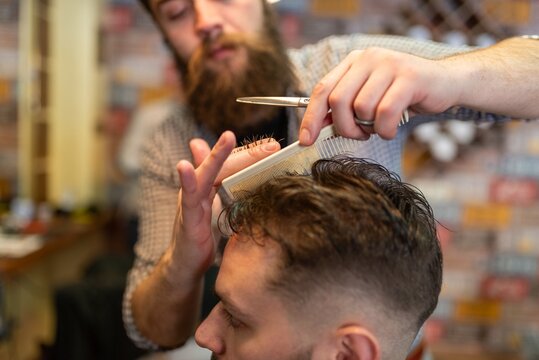 Professional men hair styling and cutting in modern barbershop salon