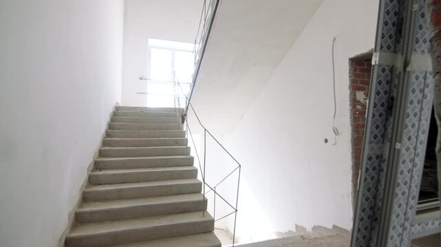 Empty concrete staircase stands in middle of active renovation process. Cold unfinished place feels quiet and ready for big changes
