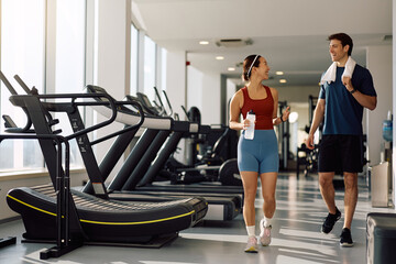 Fototapeta premium Happy athletes talking while walking through gym.