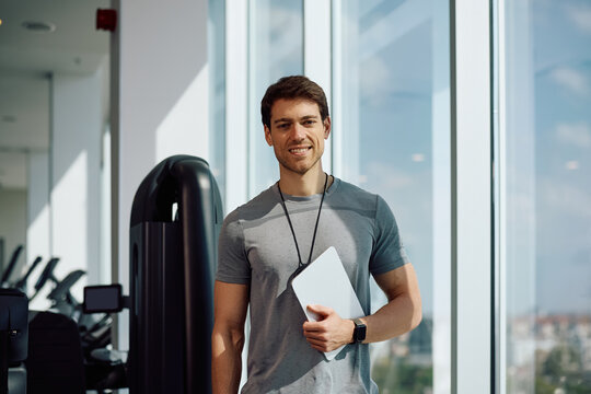 Portrait of happy fitness instructor in gym looking at camera.