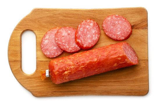 Salami sausage slices on a wooden board isolated on a white. Top view