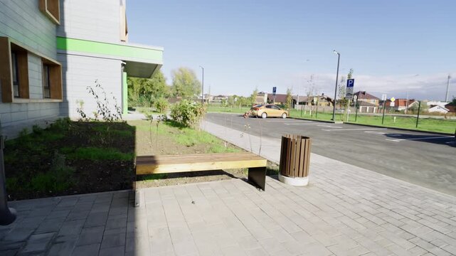 View displays newly constructed asphalt parking lot with parked cars near green lawn. Fresh urban landscaping looks exceptionally clean