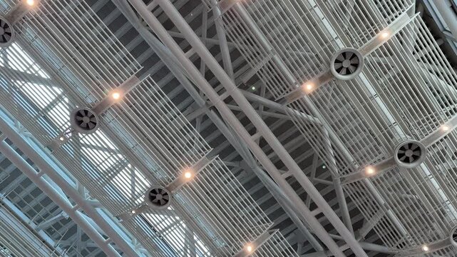 Ceiling, architecture, structure, modern airport interior with metal beams and lighting fixtures creating a geometric and industrial pattern overhead for interior design concepts