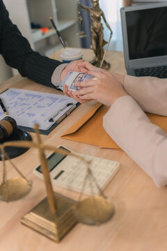 Woman hand giving bundle of money to lawyer or officer. Concept of bribery, corruption, and illegal payment in legal office. Client offering cash for lawsuit settlement or hidden financial crime.