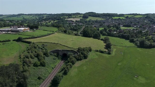 Aerial of train exiting Box tunnel with village vista on a summers day