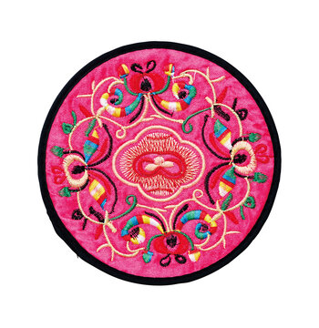 Pink silk embroidered round coaster with traditional floral pattern isolated on white background