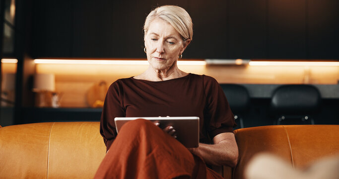 Serious, reading and woman with tablet on couch, relax or app subscription for ebook on web in house. Chilling, reader and mature person with technology, home and novel download on sofa and online