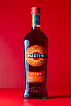 Bottle of Italian Martini Fiero aperitivo vermouth on bright red background. Minimalist studio product photography for alcohol brands, cocktail menus and bar advertising