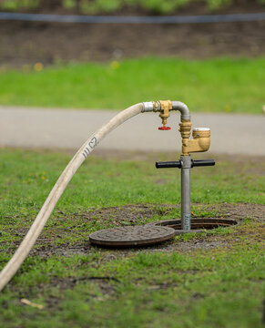 Close view of outdoor hose and brass water valve.