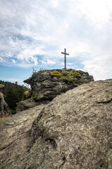 Fototapeta premium Summit cross on the Rauchröhren rock formation along Kaitersberg ridge in the Bavarian Forest, Germany.