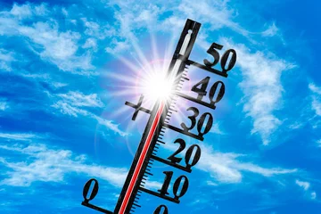 Auf einem Thermometer zeigt die Skala sehr hohe Temperatur um 40 Grad Celsius vor blauem Himmel mit strahlender Sonne - FOTOMONTAGE © Wolfilser