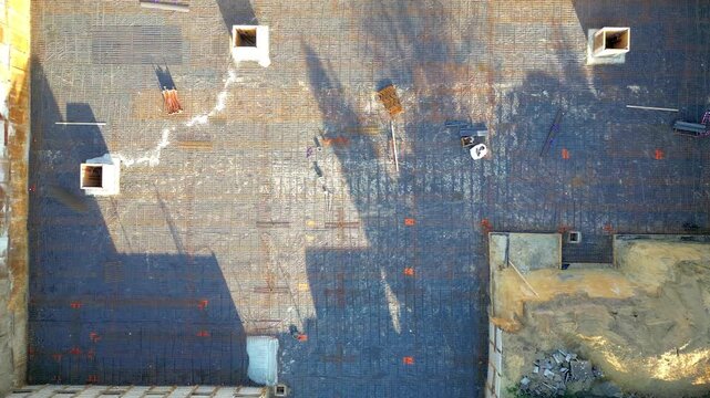 Aerial Top-Down Drone View of a Construction Site with Rebar Grid for Building Foundation