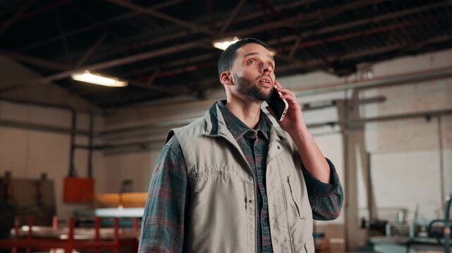 Carpentry, talk and man with phone call in workshop for project quote, new client or consultation. Manufacturing, carpenter and mobile contact for design discussion, pricing estimate and negotiation