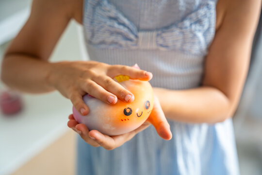 Child holds a cute squishy stress relief toy in hands at home. Sensory play and stress relief encourage relaxation, focus and emotional comfort.