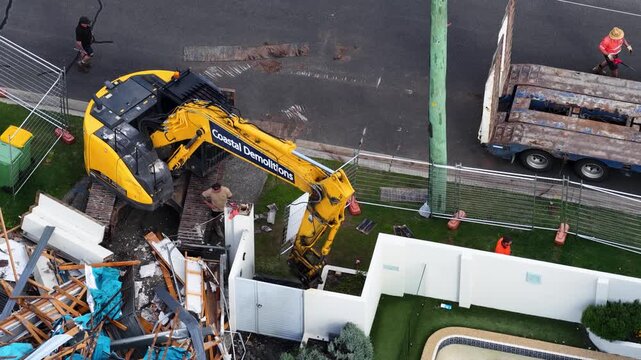 Aerial View of Yellow Excavator Demolishing Residential Building in Urban Area