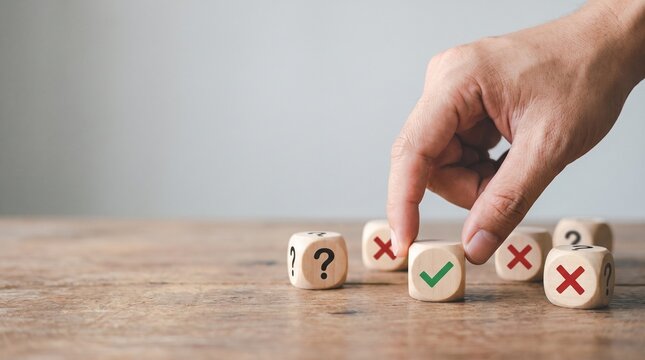 Hand choosing a wooden block with a green check mark from a group of blocks with cross marks and question marks, symbolizing decision making, right choice, and quality evaluation.