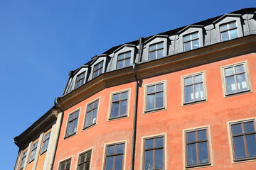 Obraz premium Colorful historic apartment building facade under clear blue sky with copy space