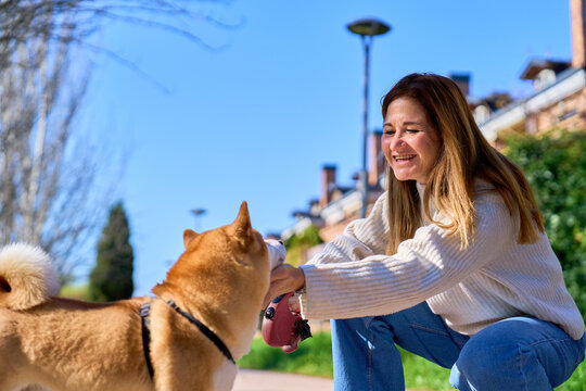Mature woman enjoying walk with her shiba inu dog