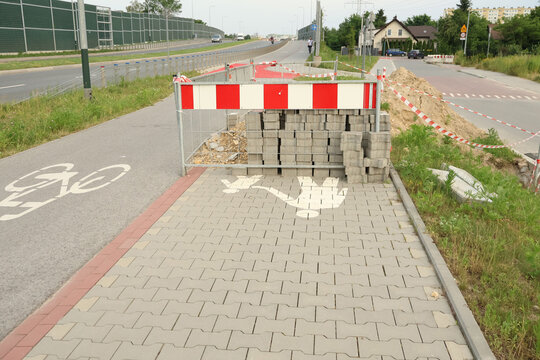 Photo of a construction site with equipment, repair work, construction materials, and no-entry signs.