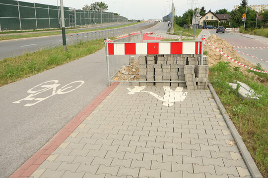 Photo of a construction site with equipment, repair work, construction materials, and no-entry signs.