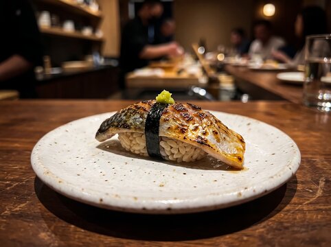 A close-up of a seared marinated mackerel (Aburi Shime Saba) sushi nigiri
