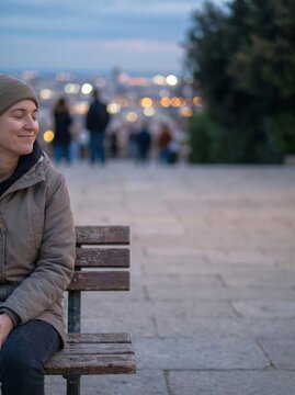 Happy woman sitting on bench with closed eyes medium shot illustrating mindfulness and tranquility in city park at twilight