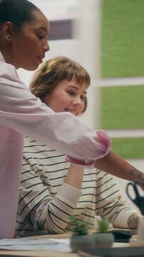 360 Degree Vertical Screen. Two Women, African American and Caucasian, Work Together at a Home Office Desk Using a Laptop for Remote Work, Online Research, and Ecommerce Shopping. Tracking Shot.