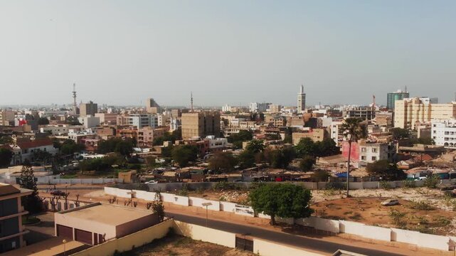 Drone pans across Dakar city center skyline with minaret and modern towers